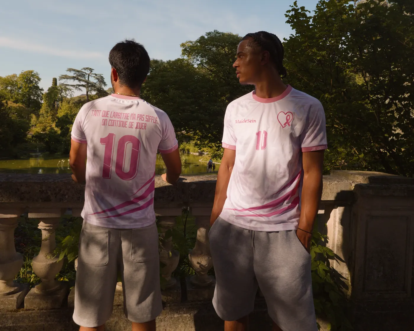 Deux jeunes hommes portent le maillot solidaire MAIDESEIN dans un parc, l’un de dos, l’autre de face